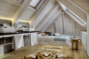 Suite bajo cubierta, encimera madera, alfombras de piel: Reforma y decoración de vivienda en Baqueira (Valle de Arán-Pirineos)