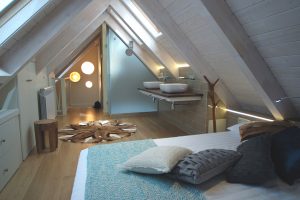 Suite bajo cubierta, techo madera blanca, dormitorio con baño: Reforma y decoración de vivienda en Baqueira (Valle de Arán-Pirineos)